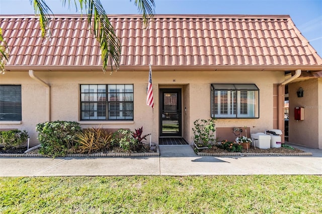 view of property featuring a tiled roof and stucco siding