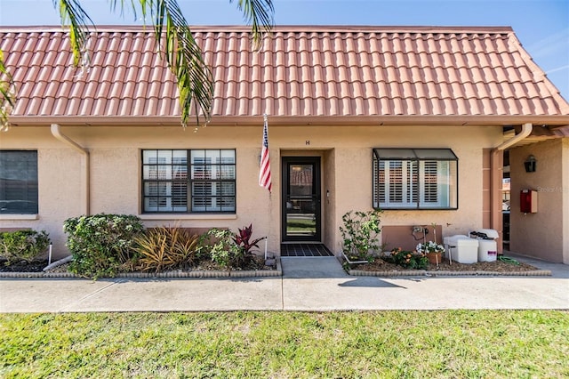 19029 US Highway 19 N Unit 30H, Clearwater, FL 33764 - townhome / multi-family property featuring stucco siding, a tiled roof, and a front lawn