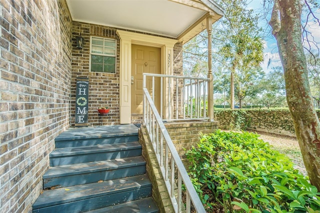 view of exterior entry with brick siding