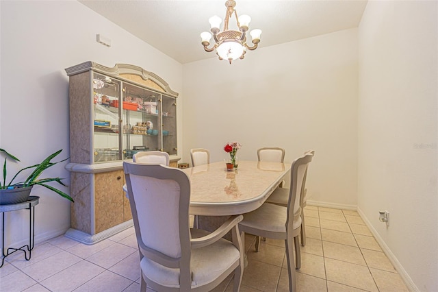 tiled dining area featuring a chandelier