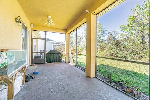 unfurnished sunroom with ceiling fan