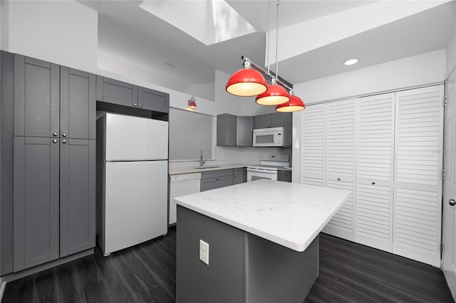 kitchen featuring gray cabinetry, white appliances, a kitchen island, hanging light fixtures, and dark wood-style floors