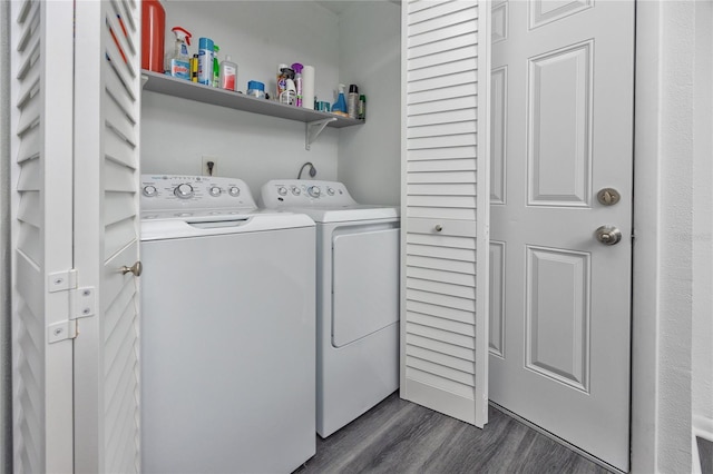 washroom with laundry area, washing machine and dryer, and dark wood finished floors