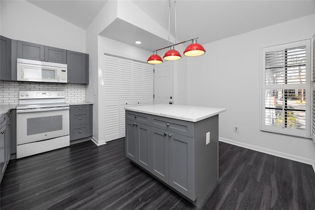 kitchen featuring pendant lighting, backsplash, gray cabinetry, a kitchen island, and white appliances