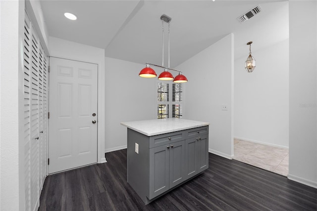 kitchen featuring pendant lighting, light countertops, visible vents, gray cabinetry, and a kitchen island