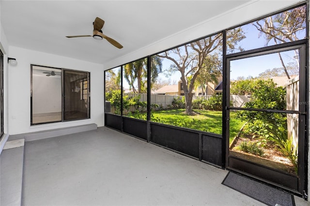 unfurnished sunroom featuring a ceiling fan