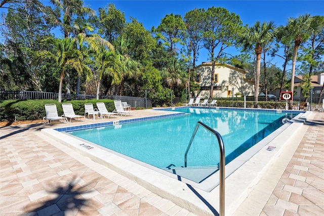 community pool featuring fence and a patio