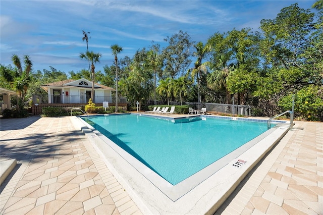 pool featuring fence and a patio