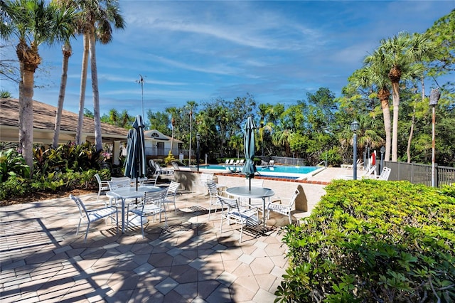 pool with a patio and fence