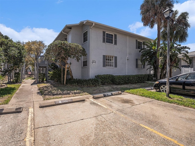 view of side of property with stucco siding and uncovered parking