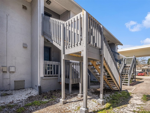 exterior space with stairway and stucco siding