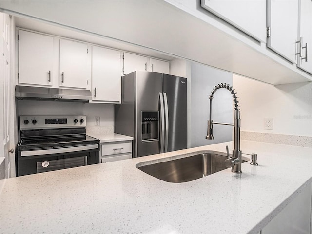 kitchen with under cabinet range hood, light stone counters, a sink, white cabinetry, and stainless steel appliances