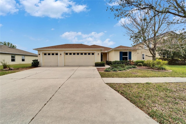 single story home featuring a garage, a front yard, concrete driveway, and stucco siding