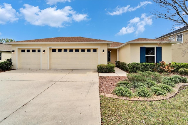 view of front of house with an attached garage, driveway, and stucco siding