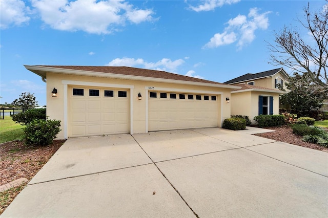 view of front facade featuring a garage, driveway, and stucco siding