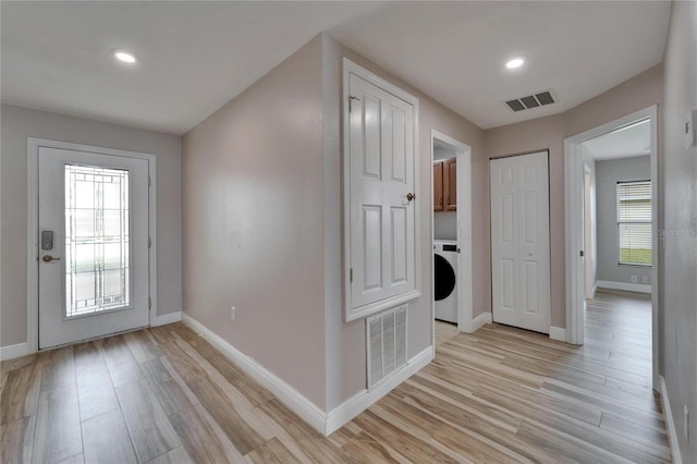 interior space featuring light wood-style floors, washer / dryer, visible vents, and baseboards