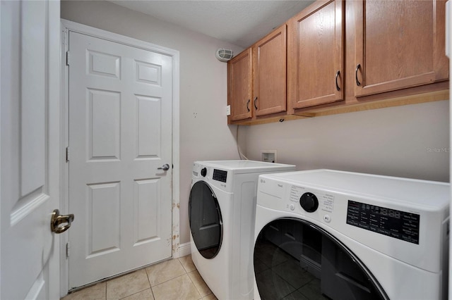 laundry room with light tile patterned floors, separate washer and dryer, and cabinet space