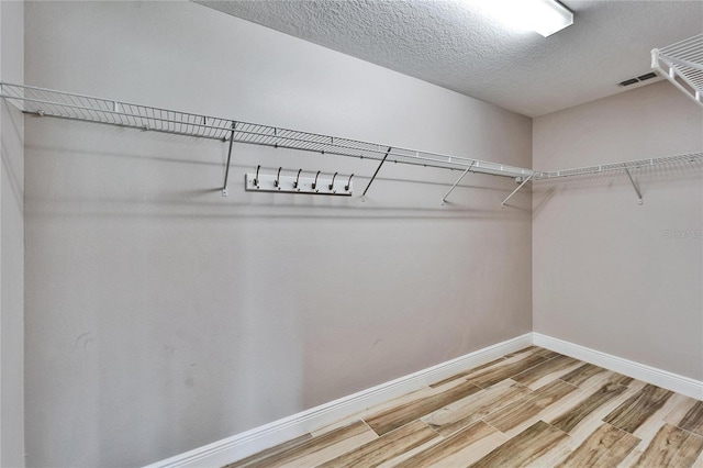 spacious closet with wood finished floors and visible vents