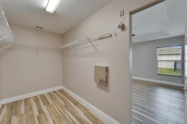 walk in closet featuring visible vents and wood finished floors