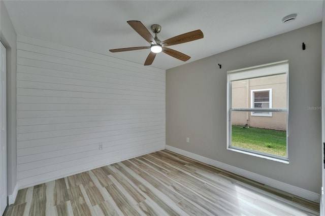 empty room with light wood-style flooring and baseboards