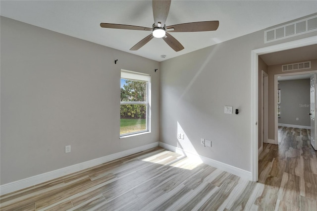 unfurnished room with baseboards, visible vents, and light wood-style floors