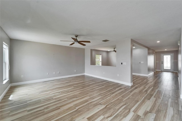 empty room featuring recessed lighting, a ceiling fan, visible vents, baseboards, and light wood finished floors