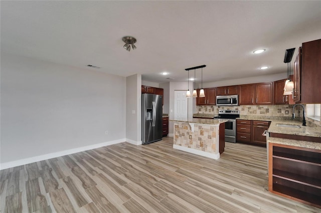 kitchen featuring a center island, decorative light fixtures, stainless steel appliances, decorative backsplash, and a sink