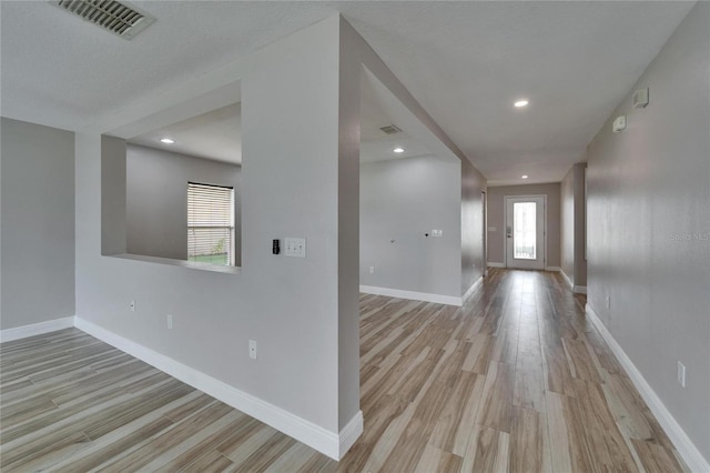 interior space featuring visible vents, light wood-style flooring, and baseboards