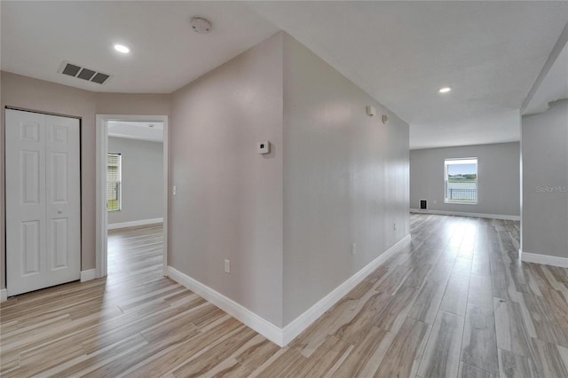 hallway with light wood-style flooring, recessed lighting, visible vents, and baseboards