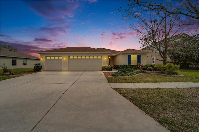 ranch-style house with a front lawn, an attached garage, driveway, and stucco siding