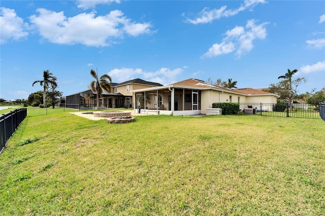 back of property featuring a yard, a fenced backyard, and a sunroom