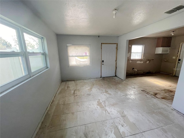 foyer entrance with a textured ceiling