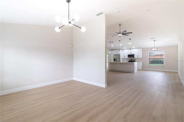 unfurnished living room featuring ceiling fan with notable chandelier and light hardwood / wood-style floors