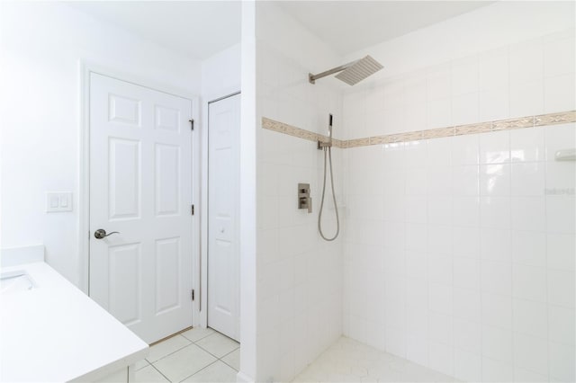 bathroom featuring tile patterned flooring and tiled shower