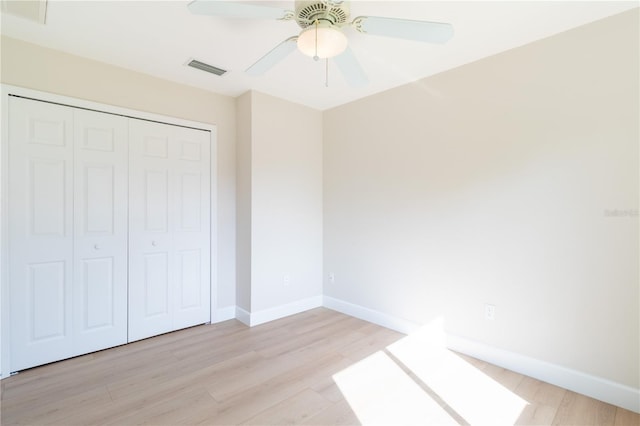 unfurnished bedroom featuring ceiling fan, light hardwood / wood-style flooring, and a closet