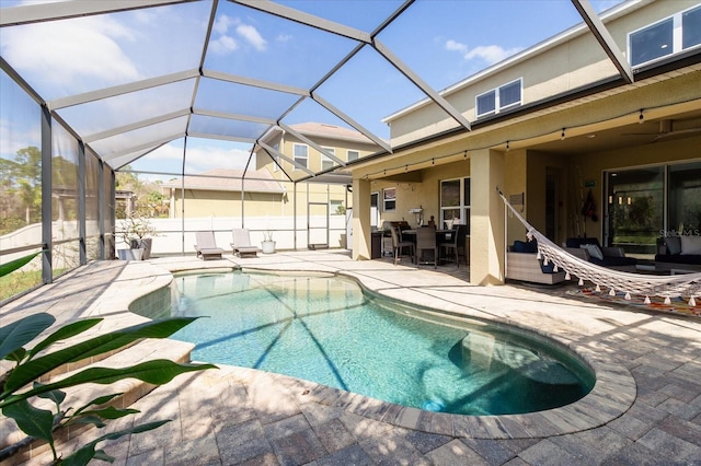 view of pool with a patio, glass enclosure, and an outdoor hangout area