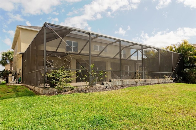 back of property with a yard and glass enclosure