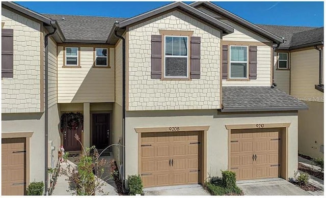 view of property with driveway, a shingled roof, an attached garage, and stucco siding