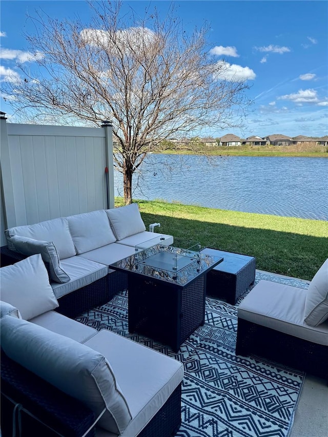 view of patio / terrace featuring a water view, fence, and an outdoor living space