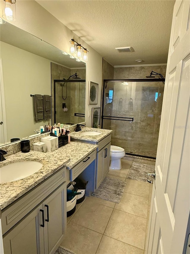 full bath featuring a textured ceiling, toilet, visible vents, a shower stall, and tile patterned floors