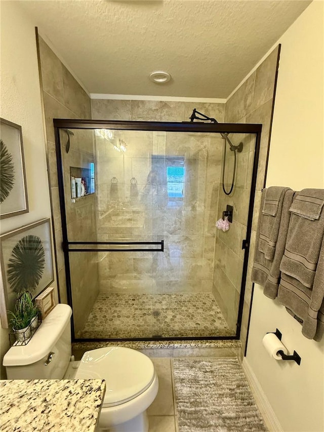 bathroom featuring crown molding, toilet, a stall shower, a textured ceiling, and tile patterned flooring