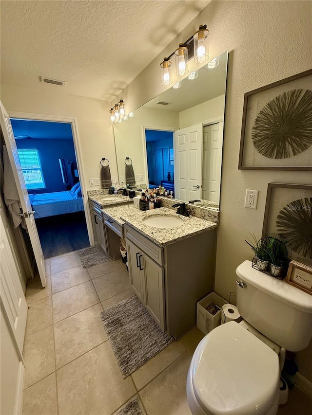 bathroom with visible vents, toilet, a textured ceiling, ensuite bath, and vanity