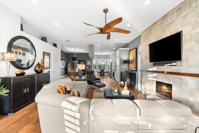 living room featuring recessed lighting, light wood-style floors, ceiling fan, and a tile fireplace