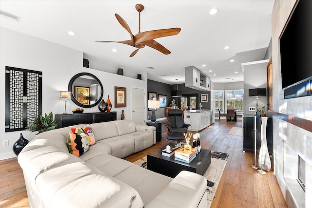 living area with light wood-style flooring, recessed lighting, a ceiling fan, and visible vents