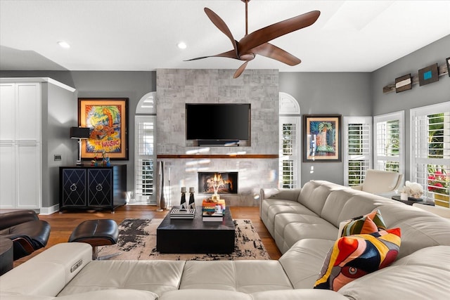 living area featuring recessed lighting, a fireplace, ceiling fan, and wood finished floors