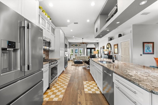 kitchen featuring visible vents, a sink, open floor plan, recessed lighting, and appliances with stainless steel finishes