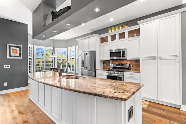 kitchen featuring a sink, light wood-style floors, white cabinetry, and stainless steel appliances