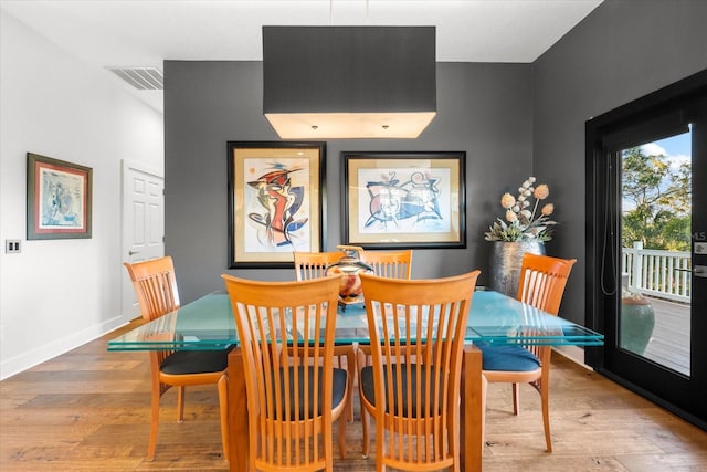 dining area with visible vents, baseboards, and hardwood / wood-style floors