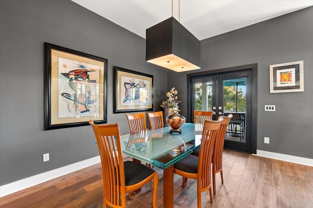 dining room featuring french doors, baseboards, and wood finished floors