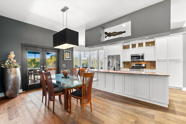 dining area featuring light wood-type flooring, french doors, and plenty of natural light